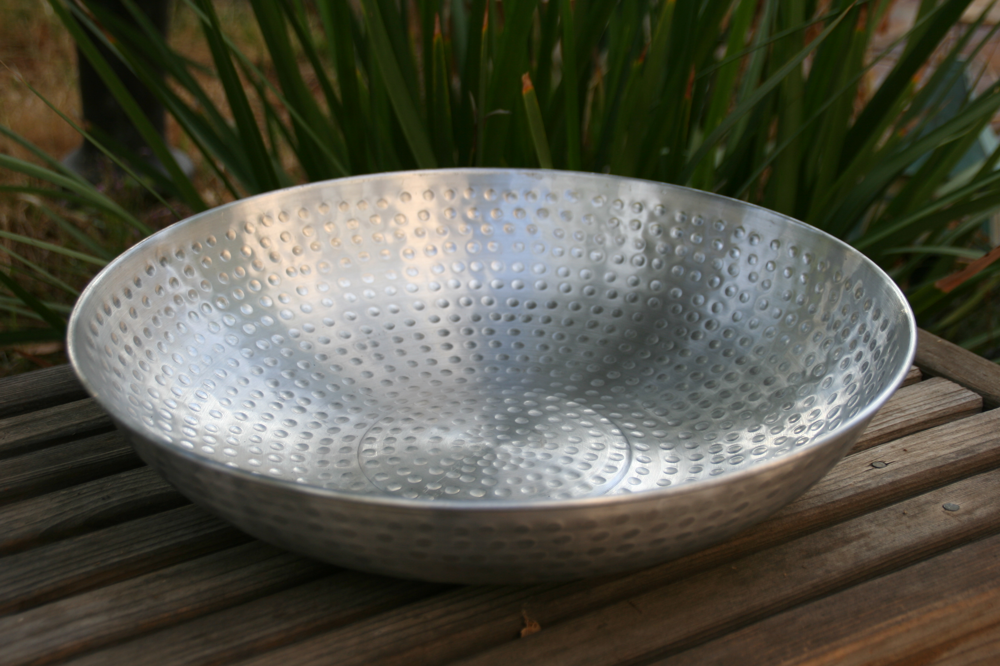 An Aluminum Dish Placed on a Wooden Panel Surface